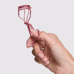 Tweezerman tea rose curler held in hand showing comfortable grip and precise control