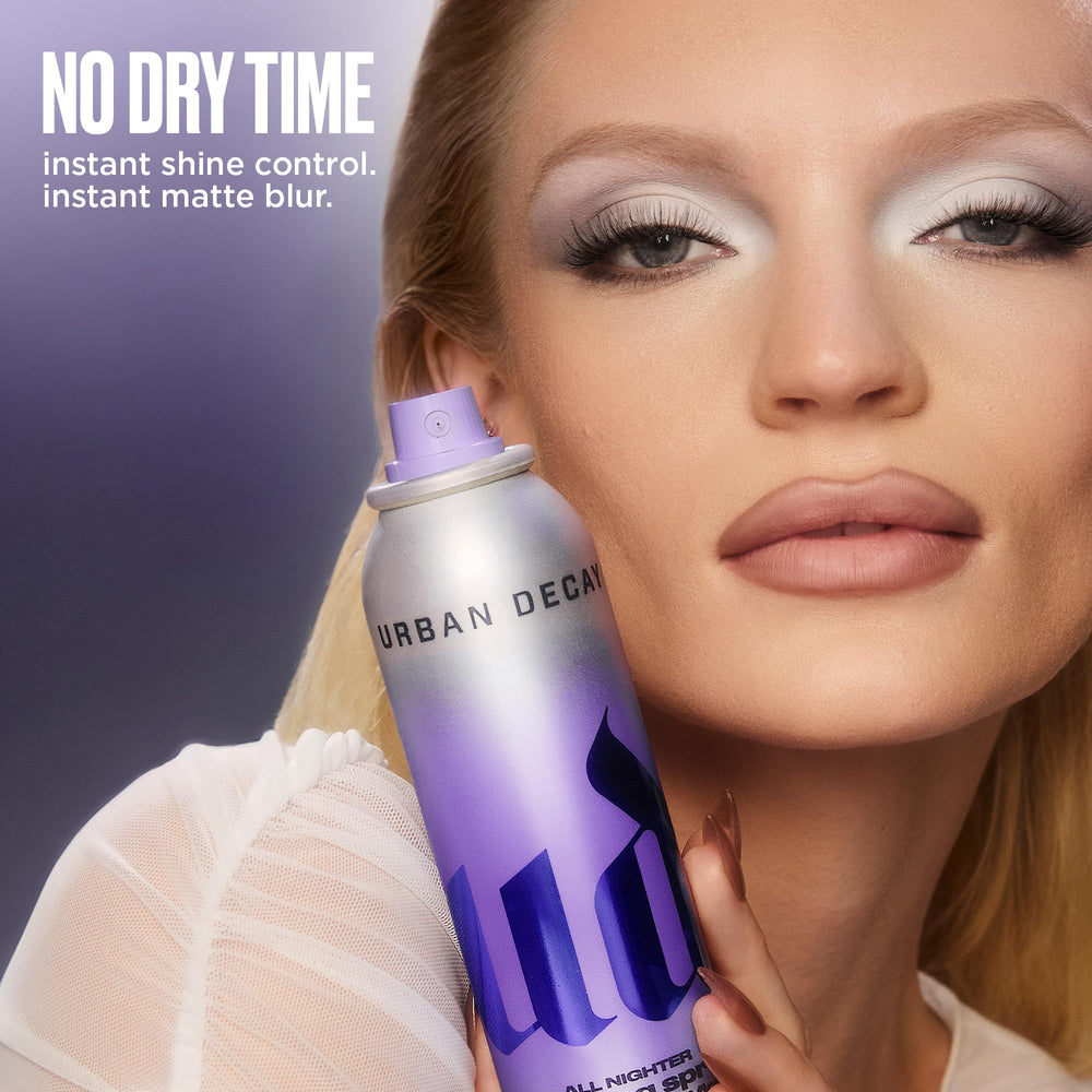 Urban Decay bottle in makeup flatlay with foundations and brushes for routine