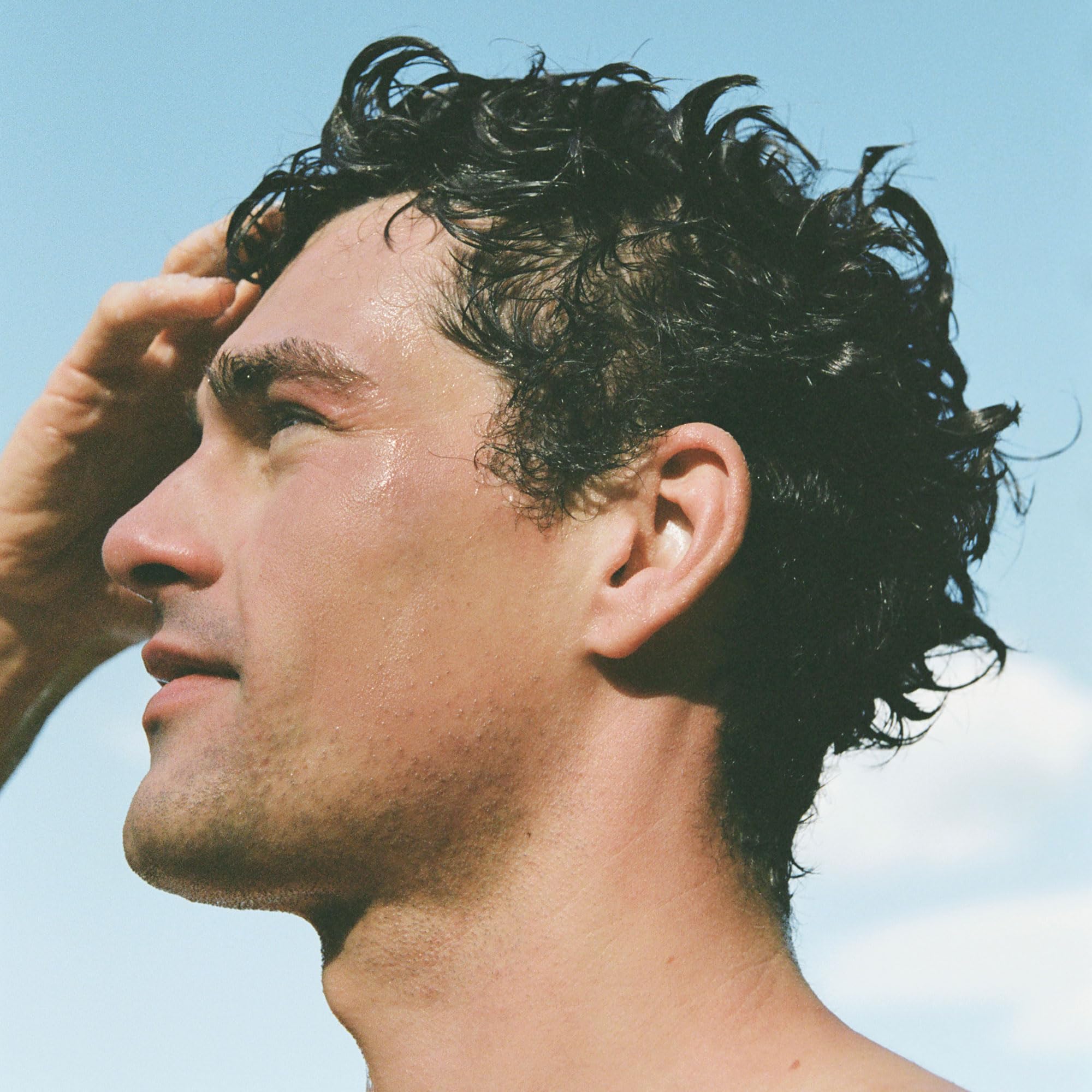 Ursa Major being applied to wet hair illustrating detangling and smoothness benefit