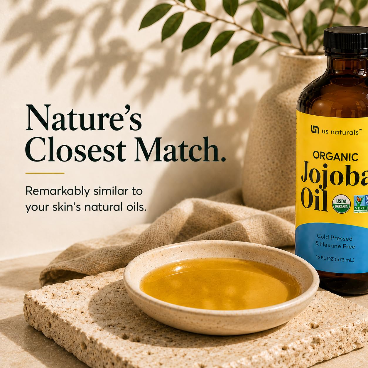 US Naturals pouring jojoba oil from bottle into spoon demonstrating measured use