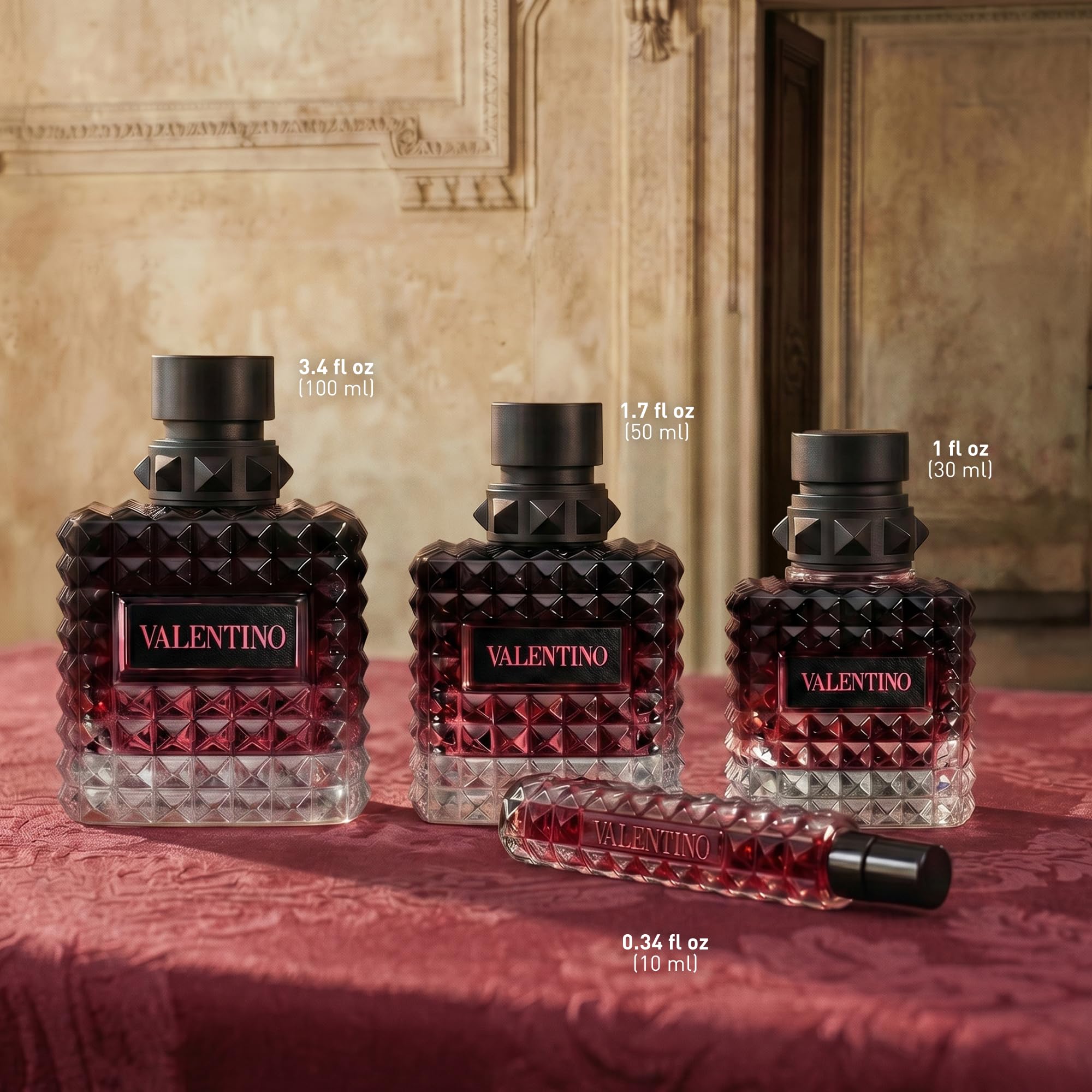 Valentino bottle beside a hand to show 3.4 oz size and portability