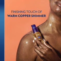Vaseline bronzing oil droplet on skin showing reflective warm copper shimmer