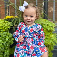 Wee Ones bow clipped in a girl's ponytail illustrating stable wear and dressed-up style