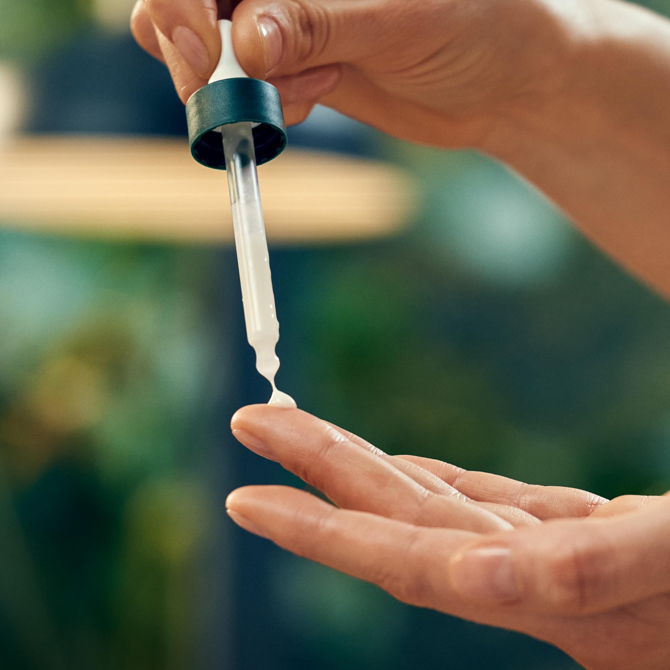 Weleda serum bottle next to hand showing size and easy daily use benefit