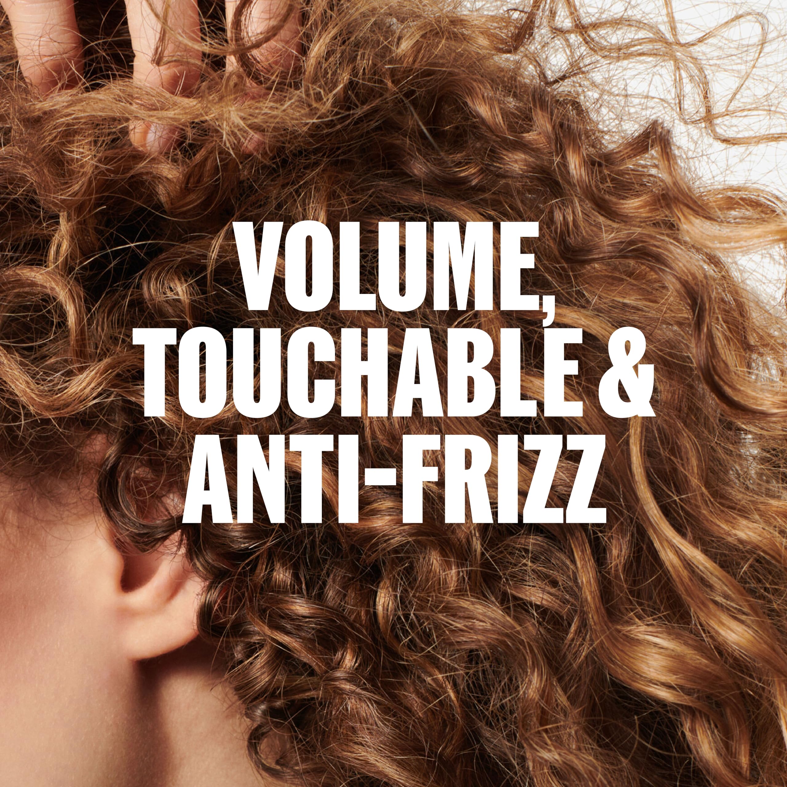 Wella Professionals applying foam to damp hair for defined, touchable waves