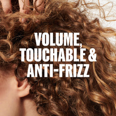 Wella Professionals applying foam to damp hair for defined, touchable waves