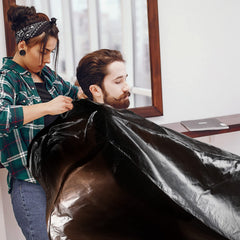 WILLBOND cape in use during haircut showing easy cleanup and client protection