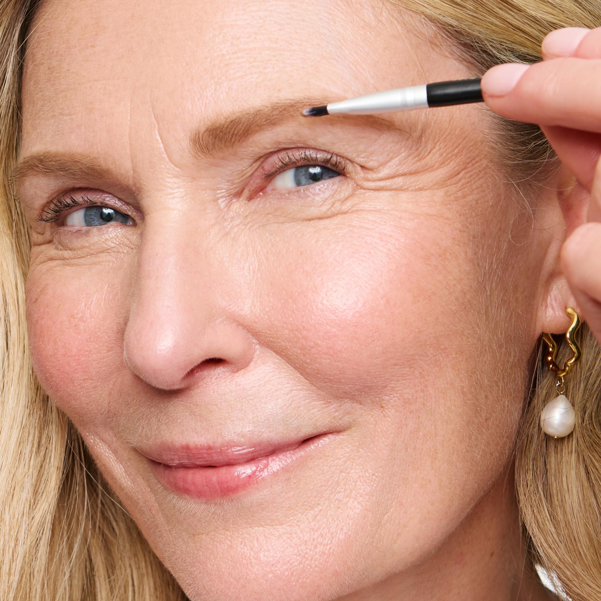WUNDERBROW compact next to coin to show size for on-the-go touch-ups